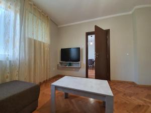 a living room with a table and a tv at Danny apartment in Burgas City