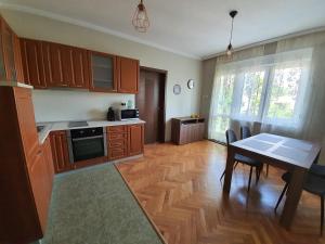 a kitchen with wooden cabinets and a table and a dining room at Danny apartment in Burgas City