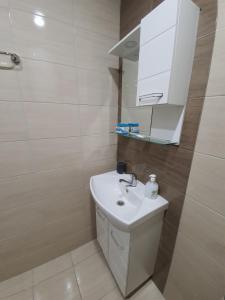 a bathroom with a white sink and a mirror at Danny apartment in Burgas City +56 photos