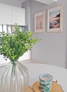 a vase with a plant in it on a table at Apartamenty Na Skarpie in Ełk