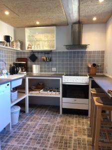 a kitchen with a stove top oven in a kitchen at Karensdal B & B in Uldum