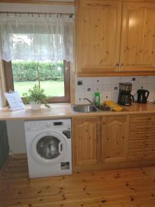een keuken met een wasmachine en een wastafel bij Apartment AliS in Tønjum
