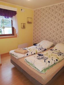 Duas camas num quarto com paredes amarelas em Apartment AliS em Tønjum