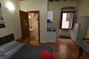 een kleine kamer met een bed en een keuken bij Via della Posterna in Spoleto