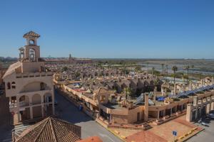 une vue aérienne sur une ville dotée d'une tour d'horloge dans l'établissement Apartamentos Turísticos Bahía Sur, à San Fernando