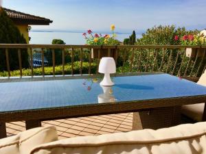a table with a lamp on top of a balcony at GardaLake View Villa in Lazise