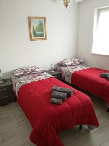 卡瓦萊塞的住宿－Villa in Val di Fiemme，红色毯子的客房内的两张床