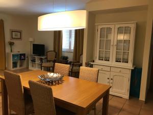 a dining room with a wooden table and chairs at Farol da Cortesia - Praia Verde in Praia Verde