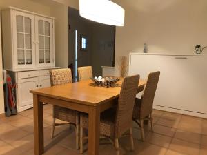 een eetkamer met een houten tafel en stoelen bij Farol da Cortesia - Praia Verde in Praia Verde