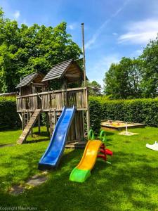 un parque infantil con tobogán y una casa de juegos en Urlaub am Wallersee, en Seekirchen am Wallersee