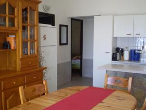 a kitchen with a wooden table and a kitchen counter at Ferienhaus nahe am Meer in Sant Lluis