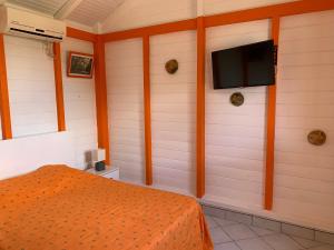 una camera con letto e TV a schermo piatto di Bungalow les Cerisiers a Bouillante