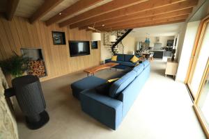 sala de estar con sofá azul y mesa en Gîte de Ty Nevez, Bretagne (Santec) spa, 300 m de la plage. en Santec
