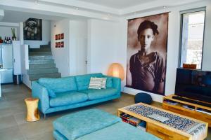 a living room with a blue couch and a tv at Kokinogremos Villa in Kalithies