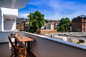 a table on a balcony with a view of a city at Sleep Inn Wehrhahn Suites in Düsseldorf