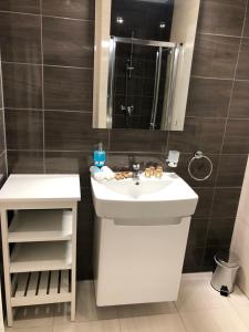 a bathroom with a white sink and a mirror at Hrebienok D407 in Starý Smokovec