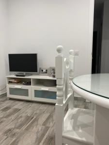 コニル・デ・ラ・フロンテーラにあるConil Apartmentの白いリビングルーム(テレビ、テーブル付)