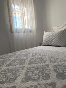 a bedroom with a bed with a window and a pillow at Conil Apartment in Conil de la Frontera