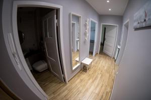 a room with a hallway with a mirror and wooden floors at Miraua 1 in Gdańsk