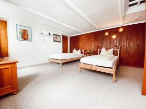 two beds in a room with wooden walls at Drei Linden Herzog in Wolfenbüttel