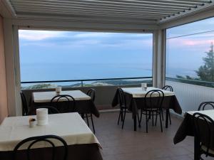 um restaurante com mesas e cadeiras e uma grande janela em B&B Angela em Monte SantʼAngelo