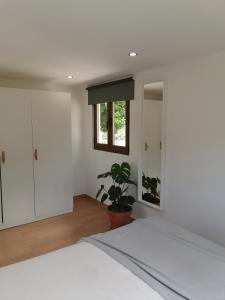 ein Schlafzimmer mit einem weißen Bett und einer Topfpflanze in der Unterkunft Casa Mendes Lopes in Celorico de Basto