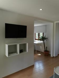 sala de estar con TV de pantalla plana en la pared en Casa Mendes Lopes, en Celorico de Basto