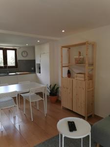Una cocina y una sala de estar con mesa y sillas. en Casa Mendes Lopes, en Celorico de Basto