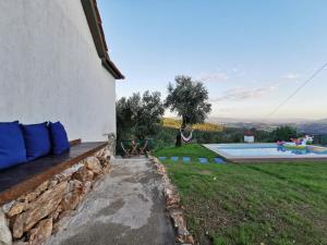 a building with a bench next to a swimming pool at Casa Mendes Lopes in Celorico de Basto