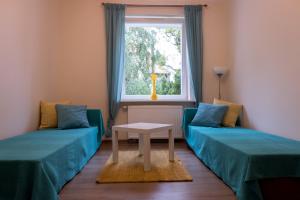 a room with two beds and a table and a window at Miraua 1 in Gdańsk