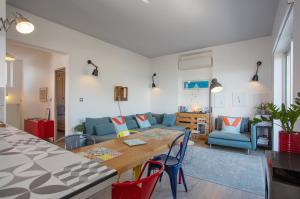 a living room with a table and a blue couch at Cassis Le 180° in Cassis