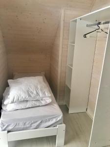 ein kleines Zimmer mit einem Bett und einem Spiegel in der Unterkunft Domki Kalmar Sarbinowo in Sarbinowo