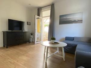 a living room with a blue couch and a table at Villa Meeresgruss in Ostseebad Sellin