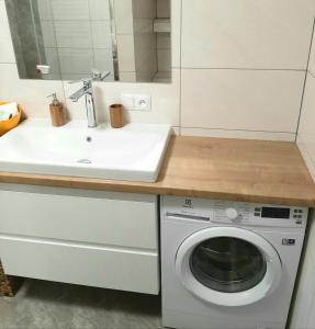 a kitchen with a sink and a washing machine at U Jagódki in Warpuny