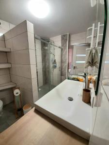 a white bathroom with a shower and a sink at U Jagódki in Warpuny