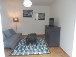 - un salon avec un canapé et une table dans l'établissement Appartement T2 ou T1 côté cour/jardin avec garage, à Rochefort