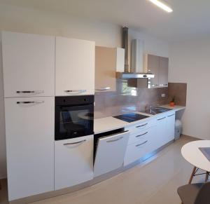 a kitchen with white cabinets and a stove top oven at Apartments & Rooms Tom in Medulin