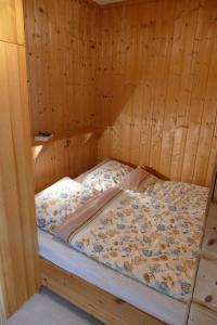 a bed in a sauna with a wooden wall at Zu Hause mit Meerblick in Fehmarn