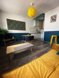 a living room with a couch and a table at La Maison Sévigné - Appart Hôtel - N°1 in Béthune