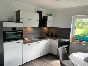 a kitchen with white cabinets and a sink at Ferienwohnungen Arkonablick in Lohme