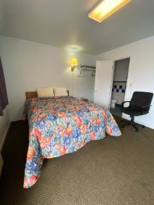 a bedroom with a bed and a desk and a chair at Regency Inn Comanche in Comanche