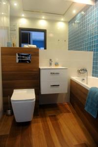 uma casa de banho com um WC, um lavatório e uma banheira em Apartament Ster Kołobrzeg em Kolobrzeg