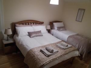 2 camas individuales en un dormitorio con toallas. en Belmullet Townhouse, en Belmullet