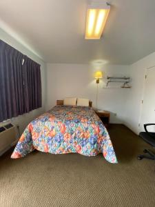 a bedroom with a bed with a colorful blanket at Regency Inn Comanche in Comanche
