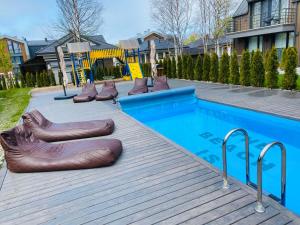 een zwembad met een heleboel opblaasbare objecten ernaast bij Family Studio VAIVORYKSTE in Palanga