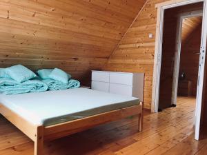 a bedroom with a bed in a wooden room at Domek letniskowy in Łukęcin