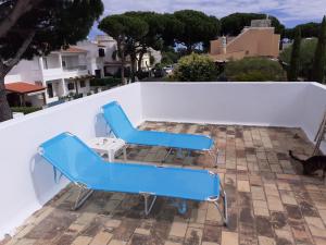 two blue chairs and a table on a roof at Eucalipto in Faro