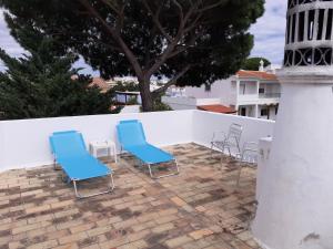 two blue chairs sitting on a patio next to a lighthouse at Eucalipto in Faro +17 photos