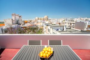 un bol d'oranges assis sur une table sur un balcon dans l'établissement Dreamers Duplex with Seaview, à Faro