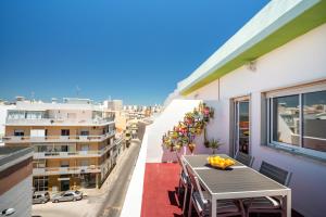 Una mesa en un balcón con vista a una ciudad. en Dreamers Duplex with Seaview, en Faro